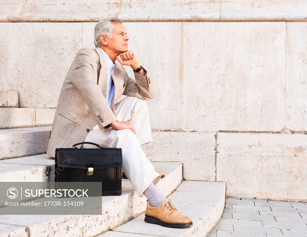 Businessman thinking on stone steps