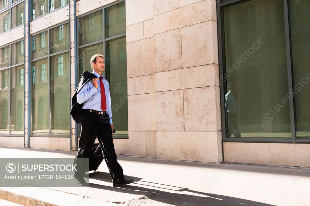 Businessman rolling luggage outdoors