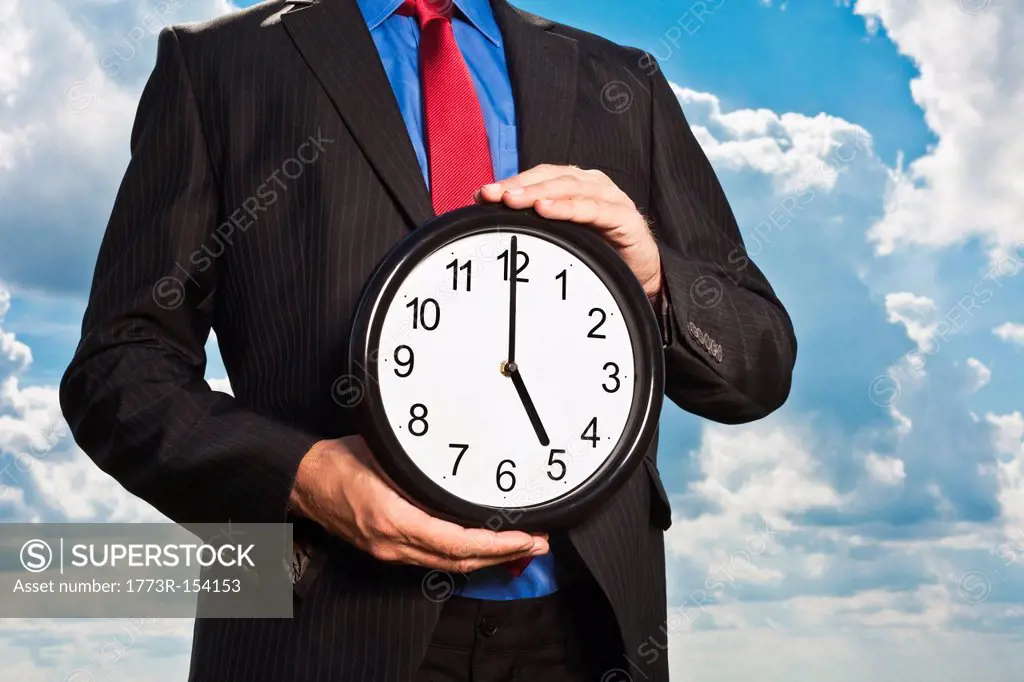 Businessman holding clock