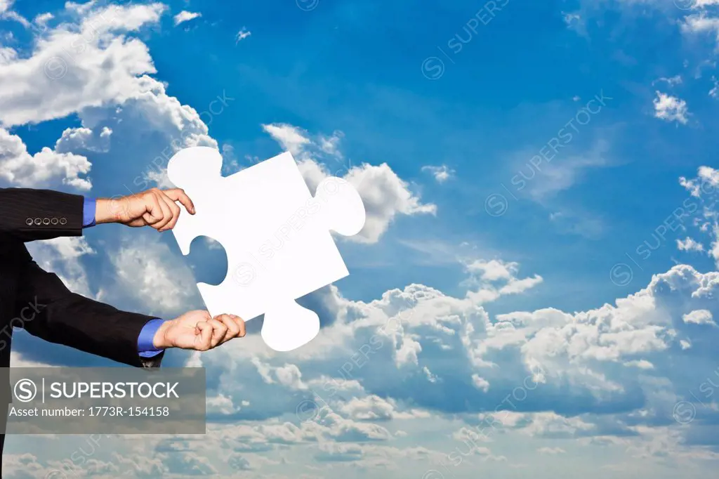 Businessman holding puzzle piece
