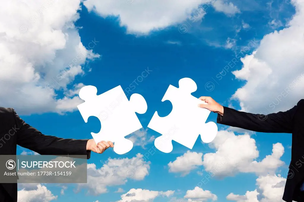 Businesspeople holding puzzle pieces