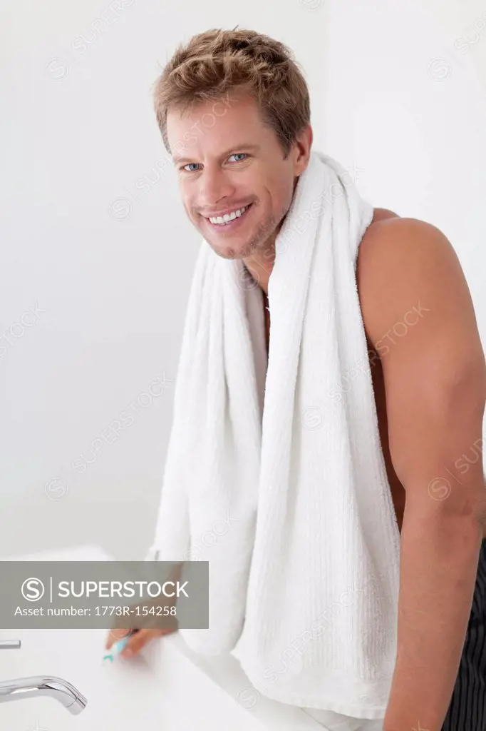 Smiling man with towel in bathroom