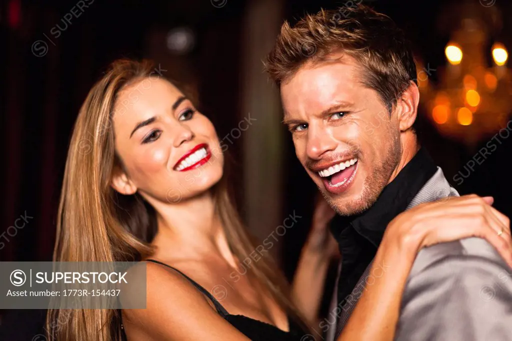 Smiling couple dancing in club