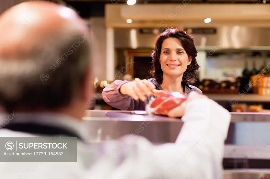 Woman buying meat from butcher