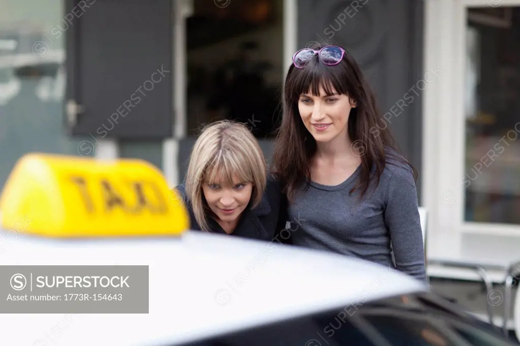 Women taking taxi cab in city