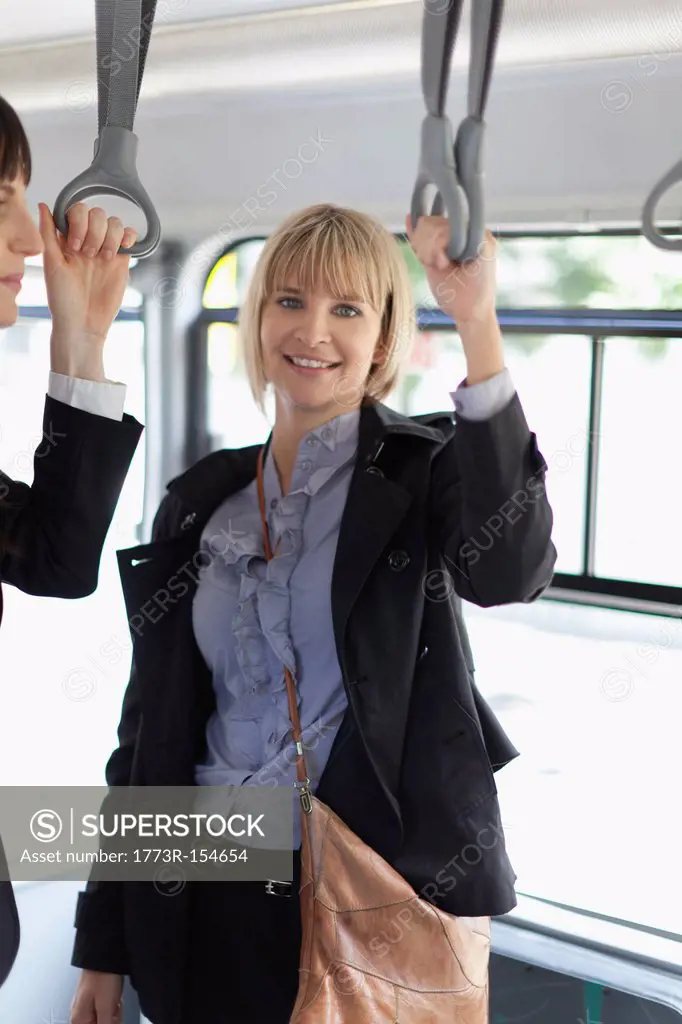 Smiling businesswomen riding the bus