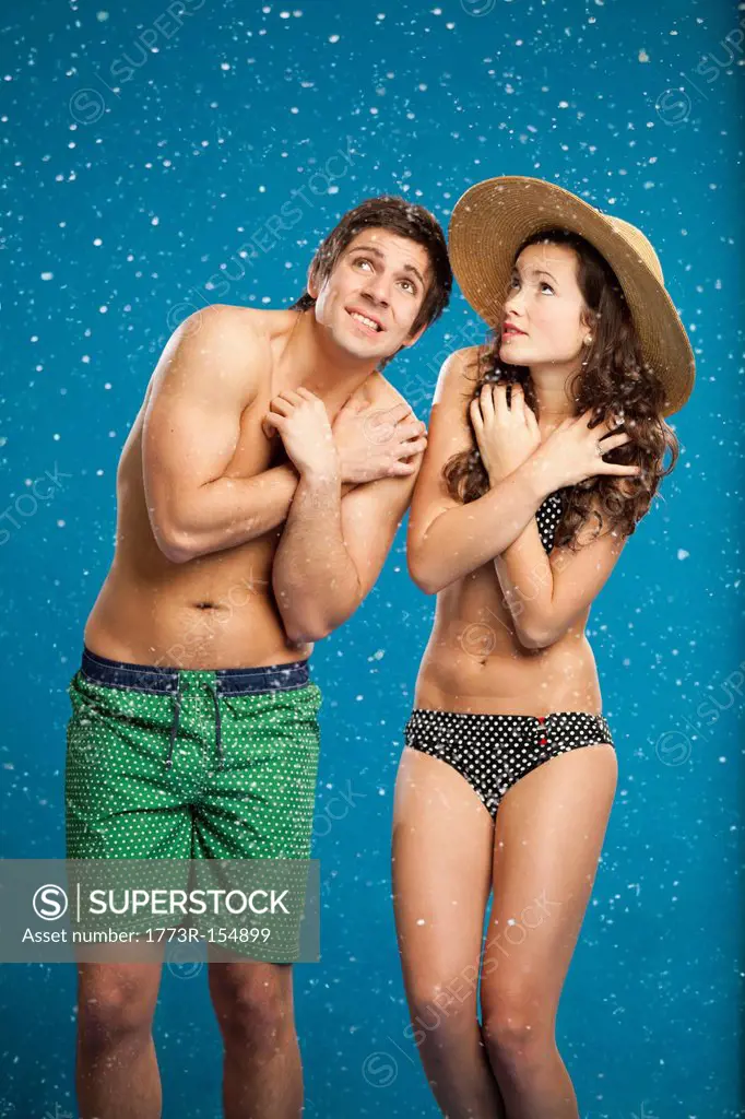 Couple in swimsuits shivering in snow