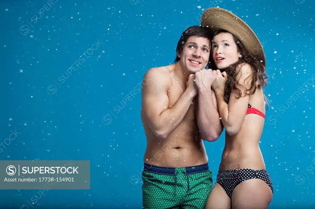 Couple in swimsuits shivering in snow