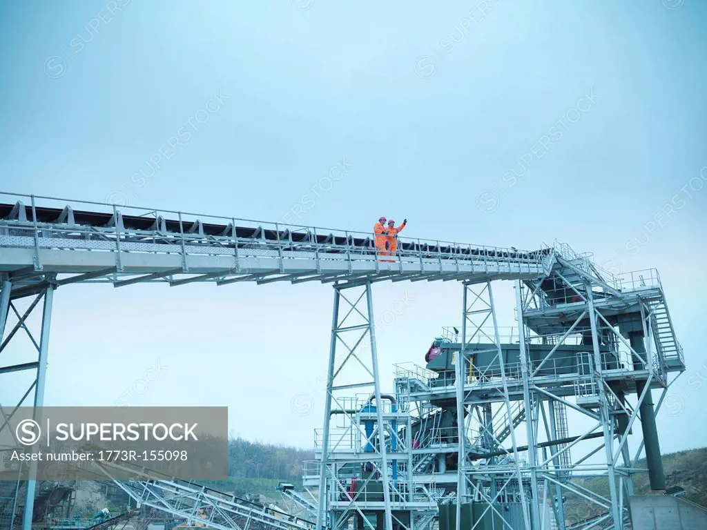 Worker climbing screening conveyor
