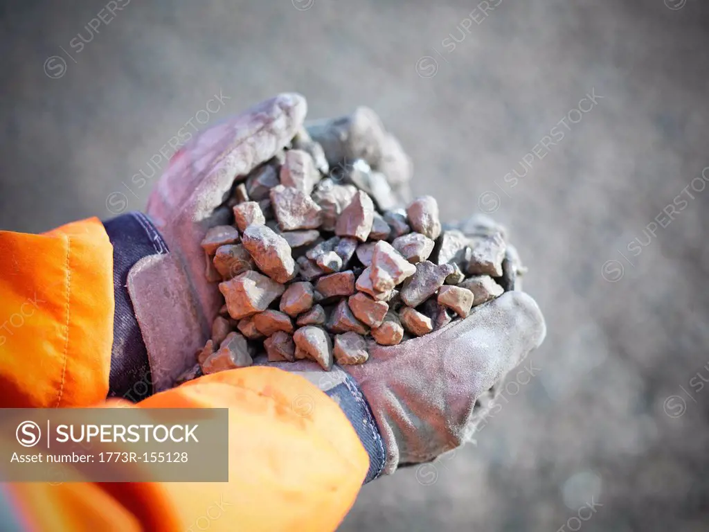 Worker with handful of quarry rocks
