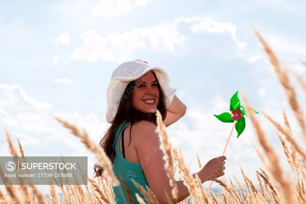 Woman holding pinwheel in wheatfield