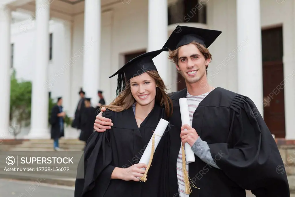 Graduates with their degrees on campus
