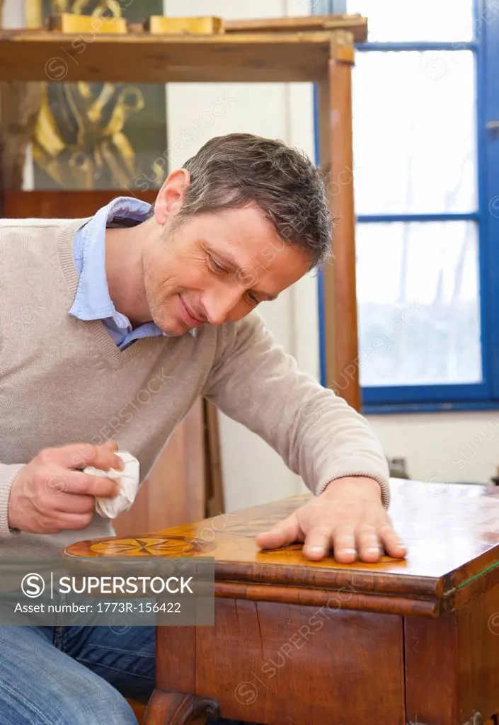 Carpenter buffing wooden table