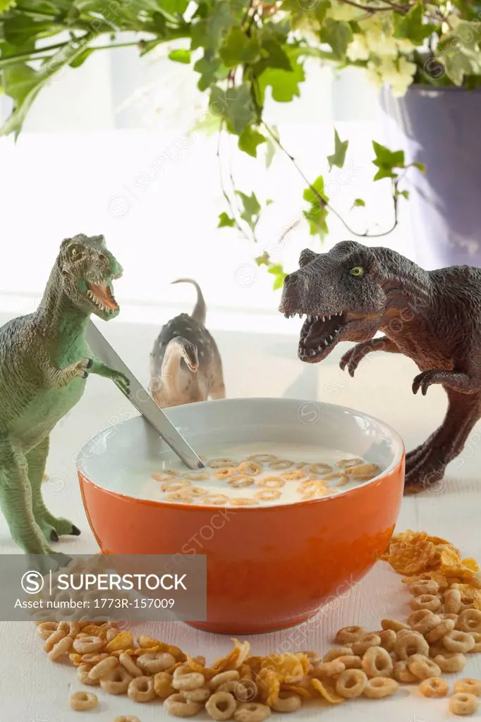 Toy dinosaurs with bowl of cereal