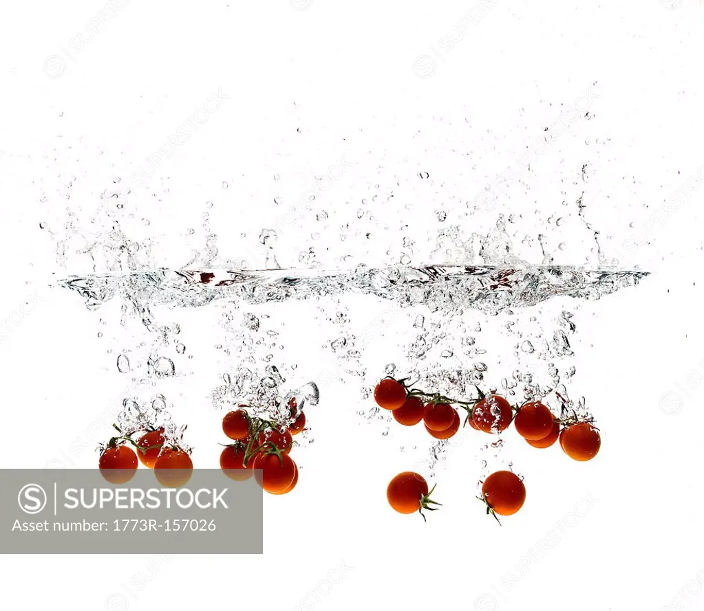 Cherry tomatoes splashing in water