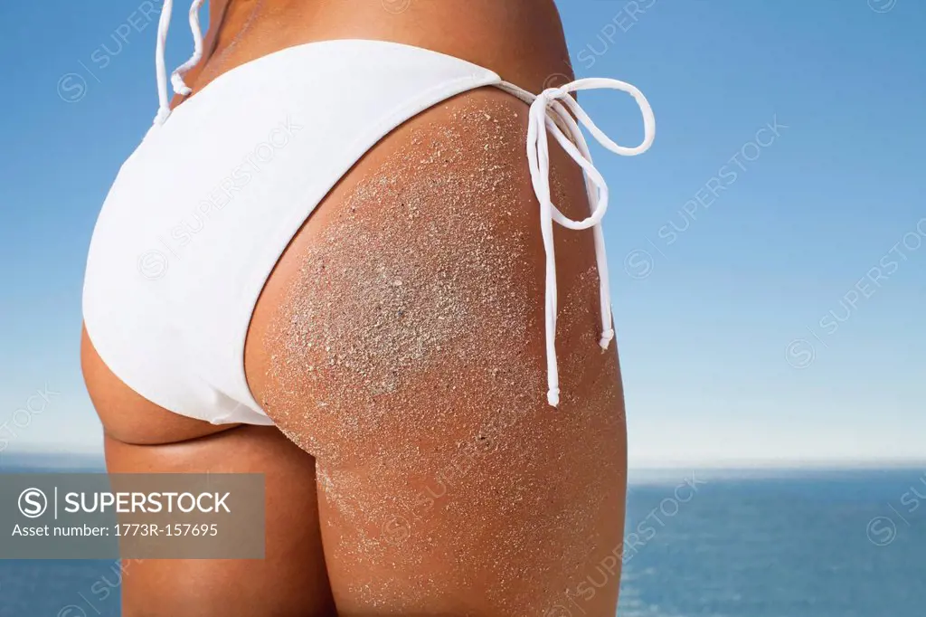 Woman in bikini covered in sand