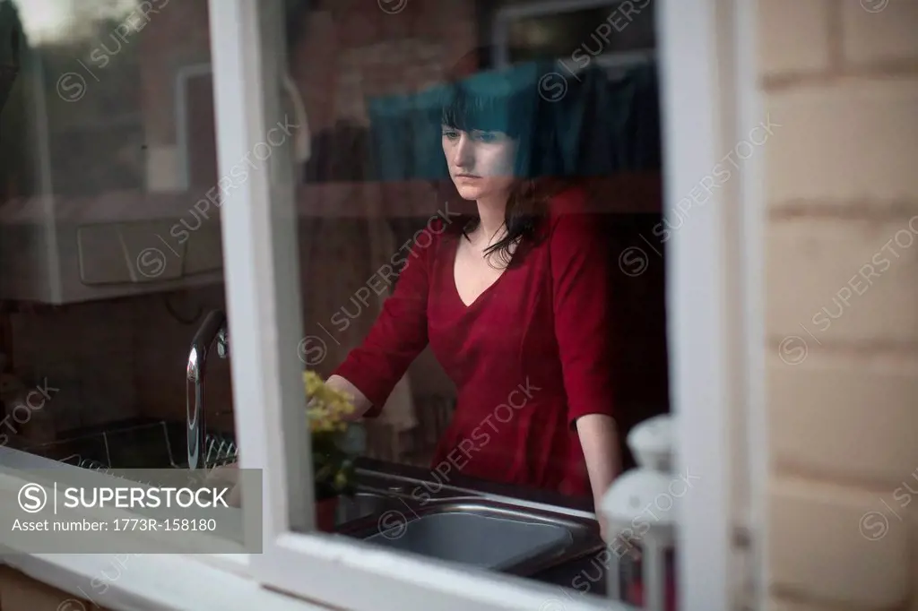 Disappointed woman standing in kitchen