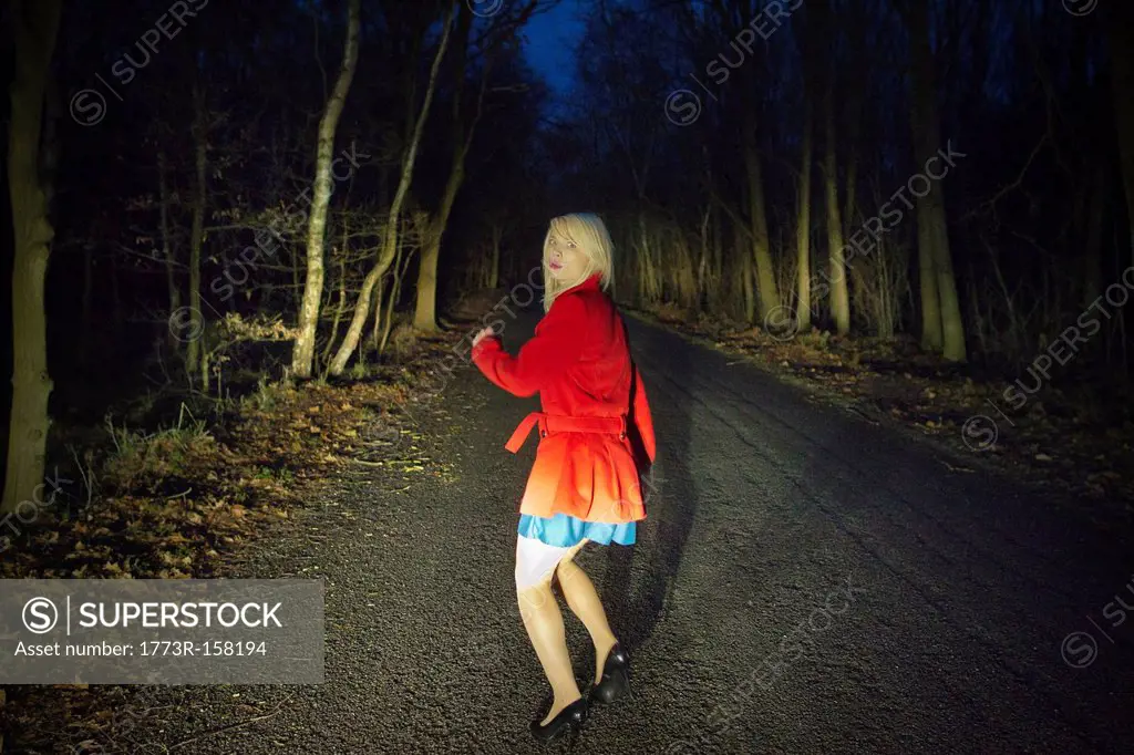 Woman running in fear in woods at night