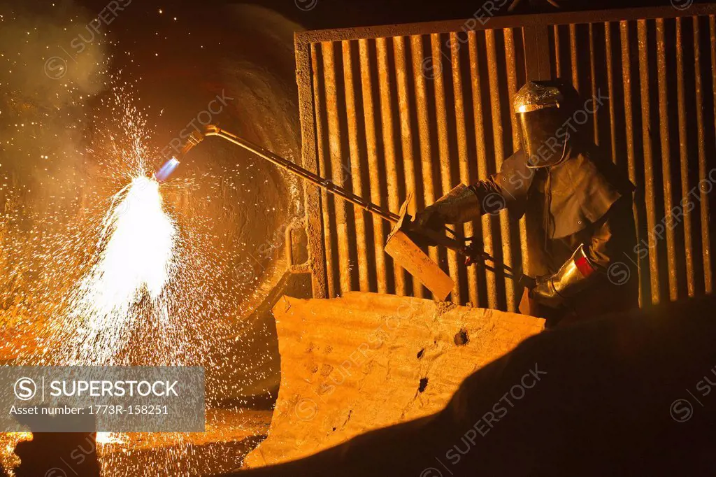 Welder at work in steel forge