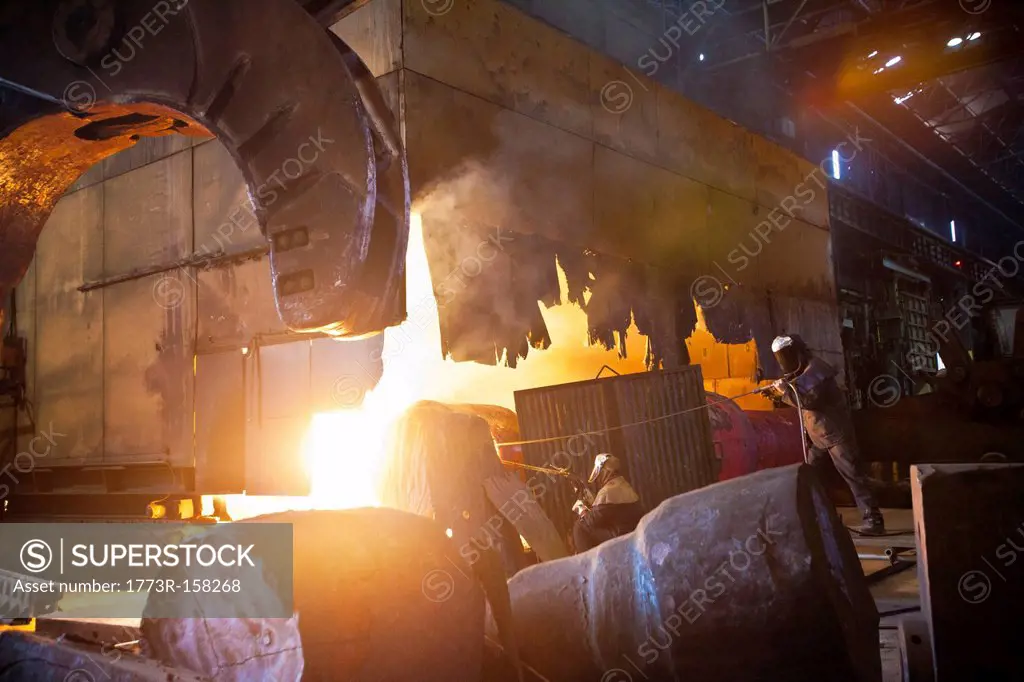 Welders at work in steel forge