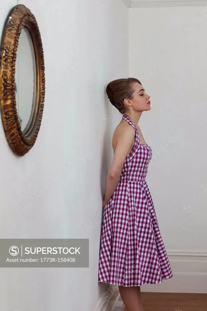 Woman leaning on wall in hallway