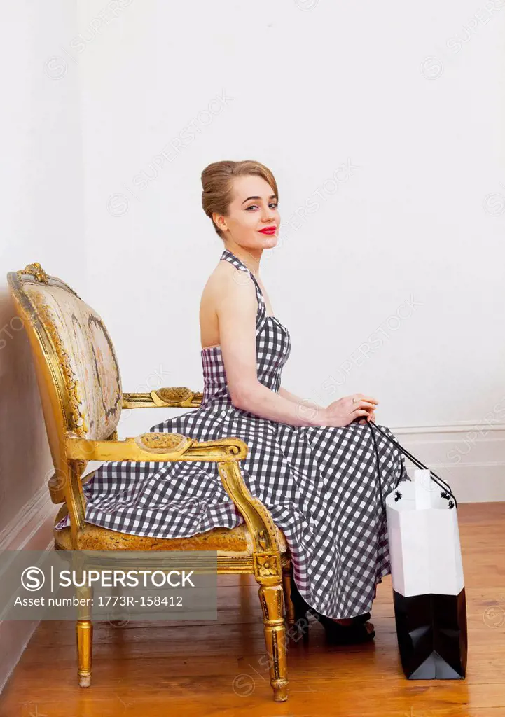 Woman with shopping bag in ornate chair