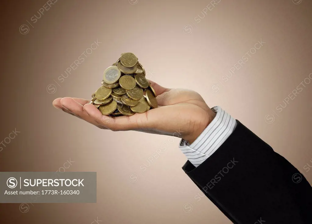 Businessman holding stack of Euro coins