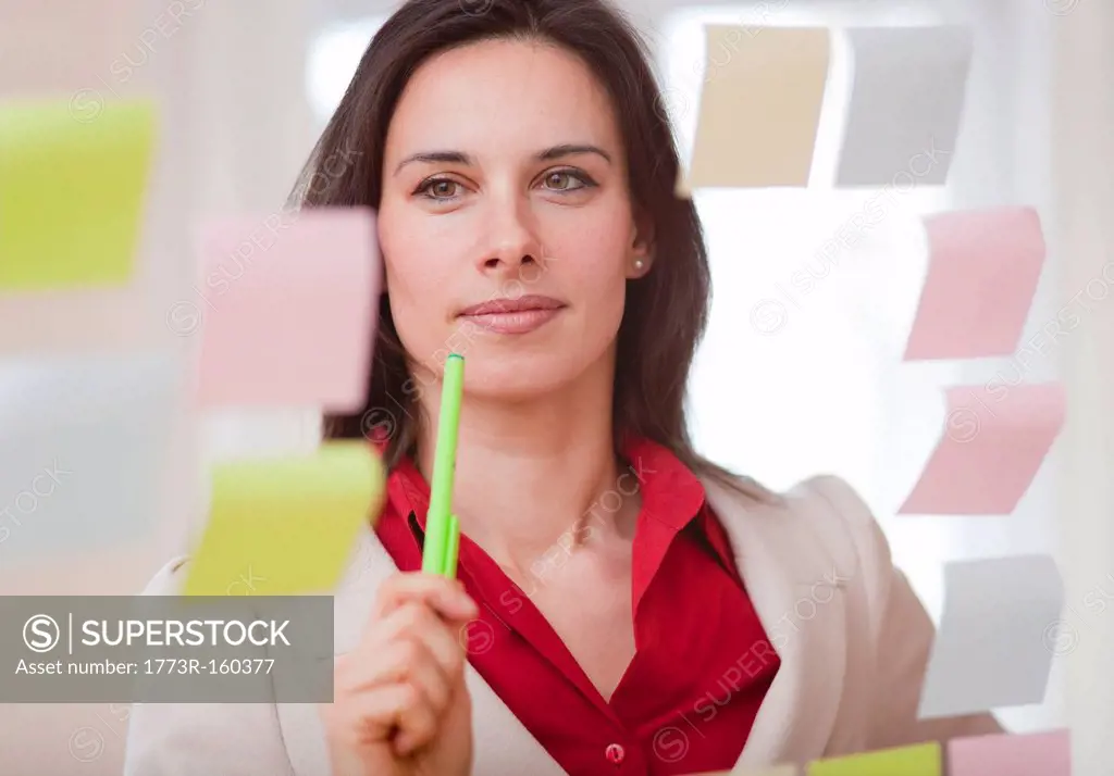 Businesswoman reading sticky notes