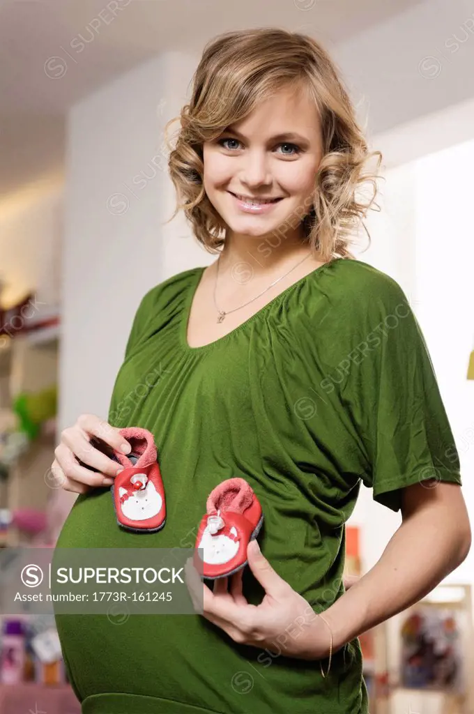 Pregnant woman buying baby shoes