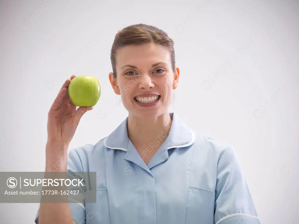 Smiling dentist holding apple