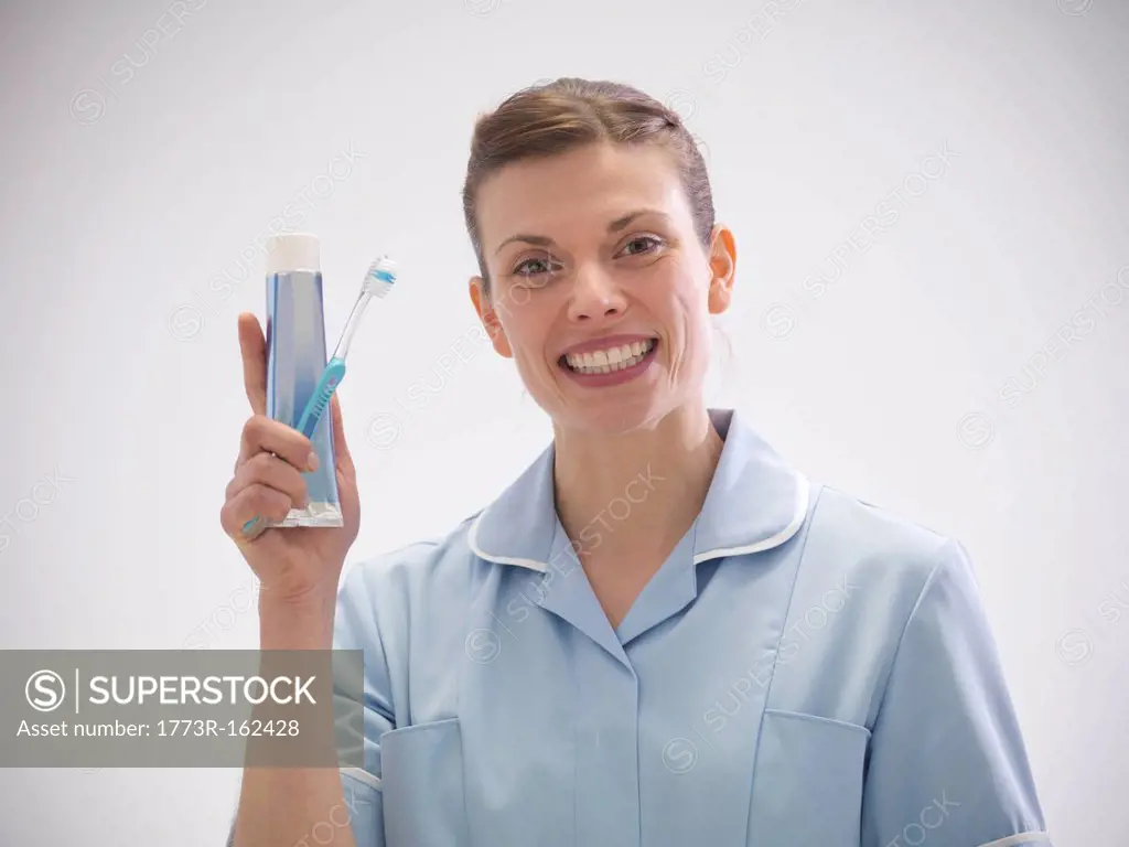 Smiling dentist holding toothpaste