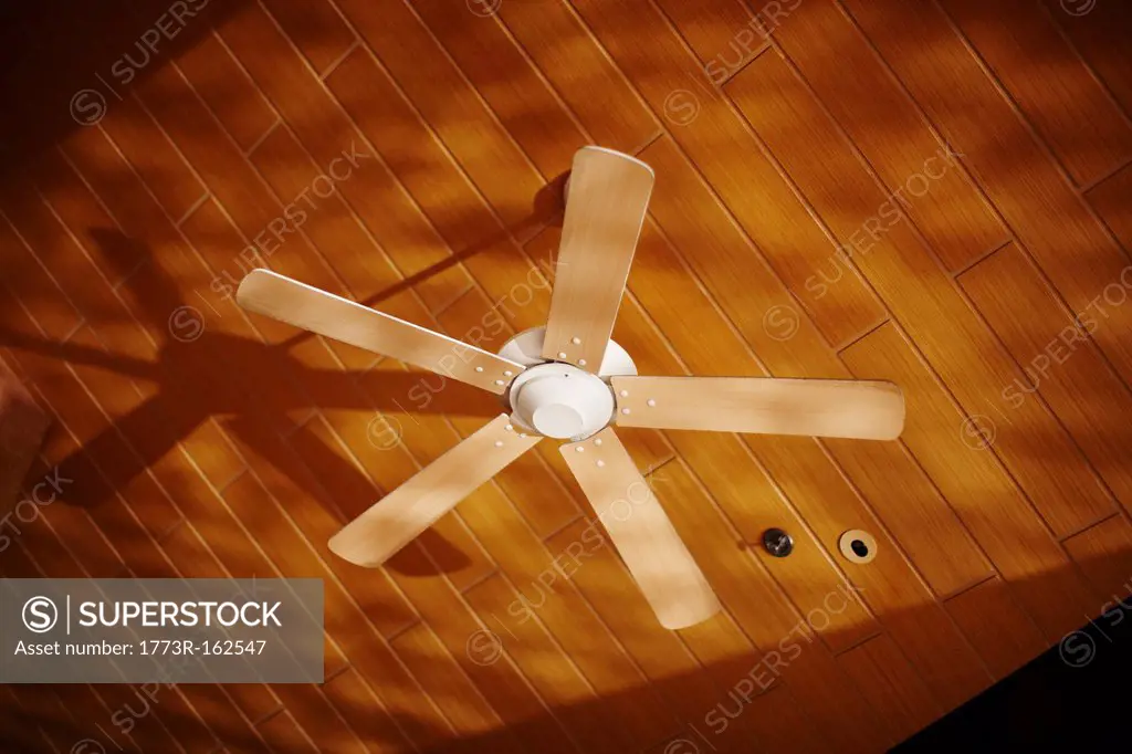 Wooden ceiling fan casting shadows
