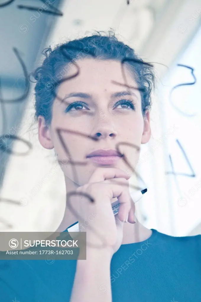 Businesswoman writing on glass