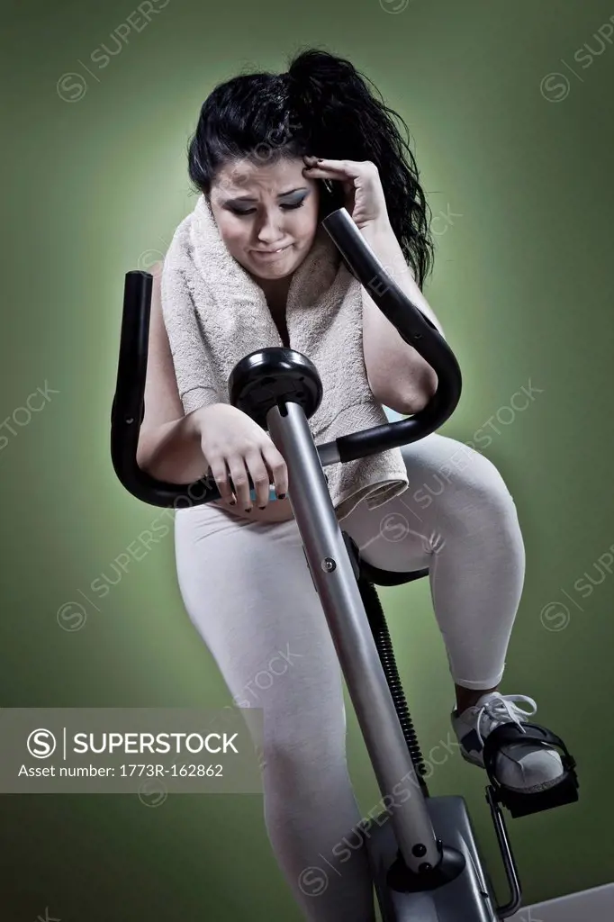 Woman using exercise bike at home