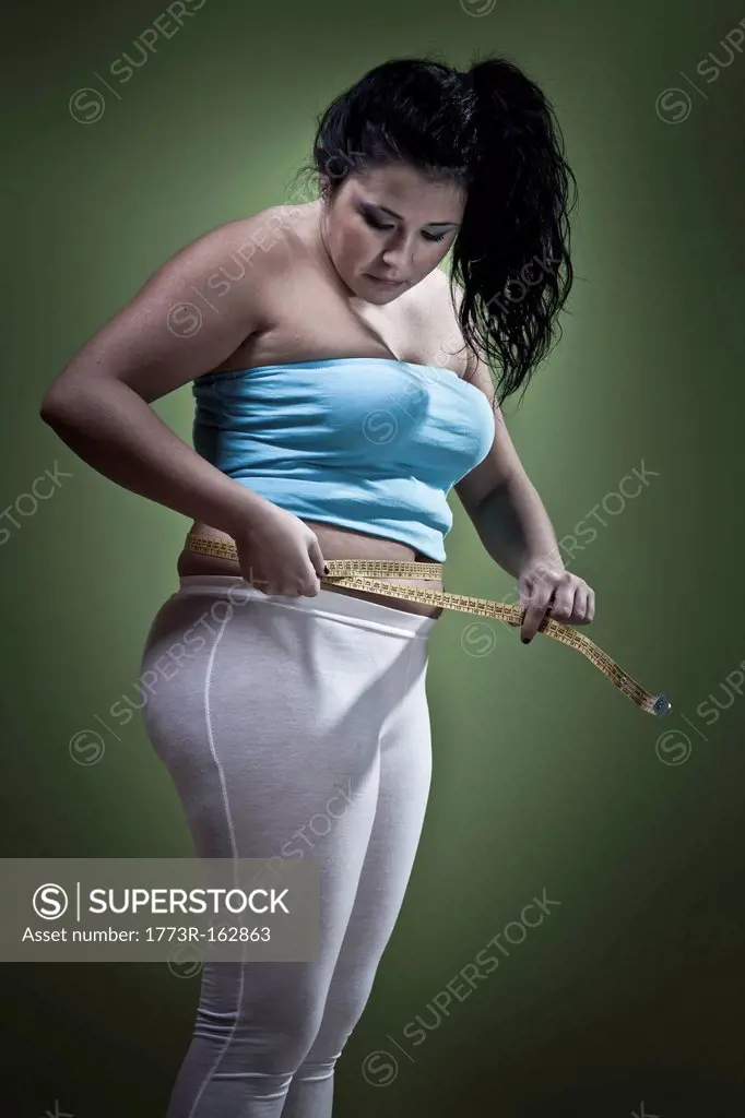 Woman measuring her waistline