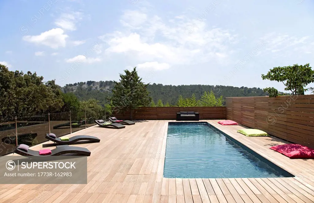 Lawn chairs and pool on modern deck