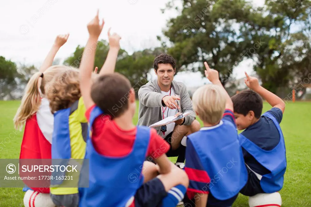 Children raising hands during practice