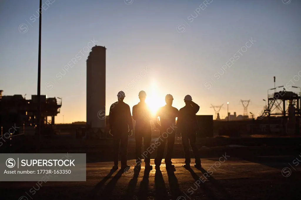 Silhouette of workers at oil refinery