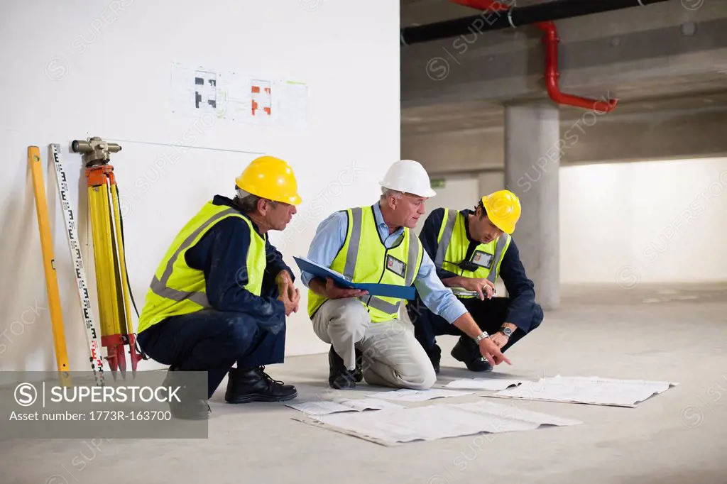 Workers reading blueprints on site