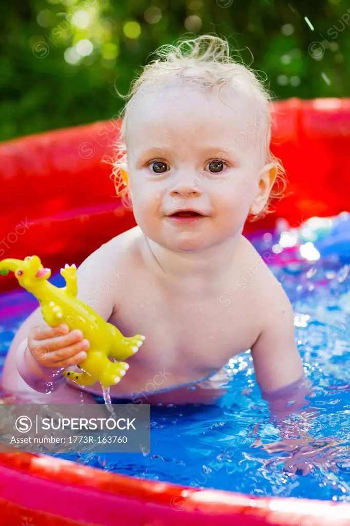 Toddler playing in inflatable pool