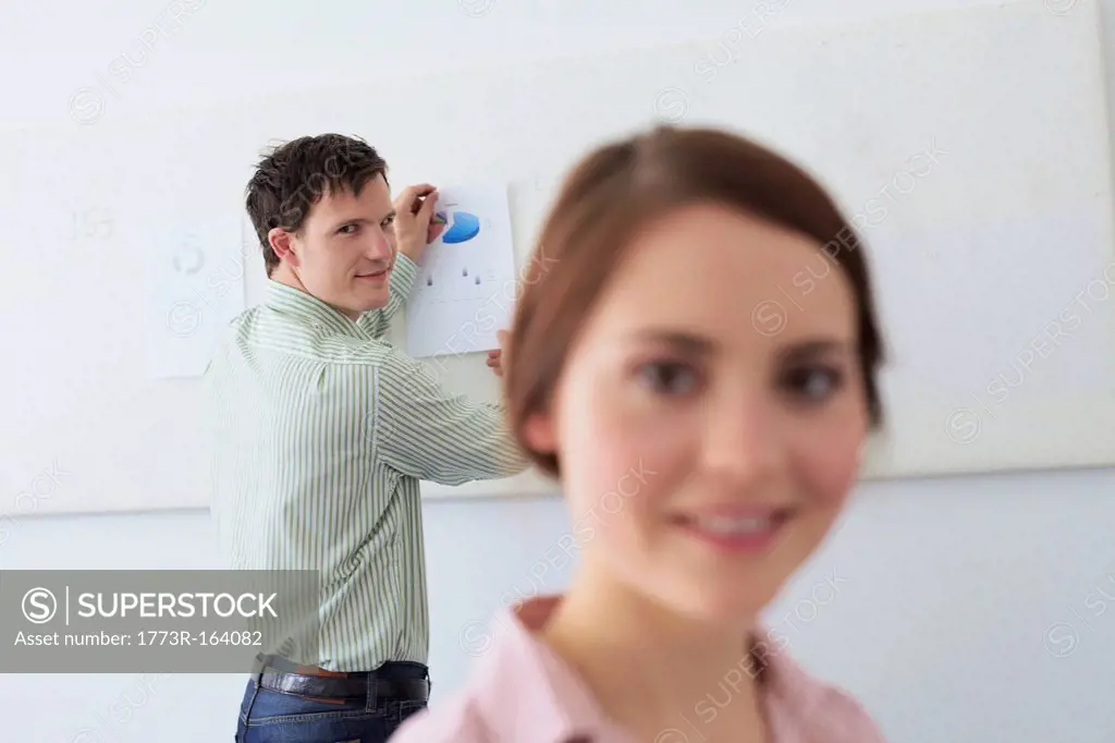 Businessman tacking up sign in office