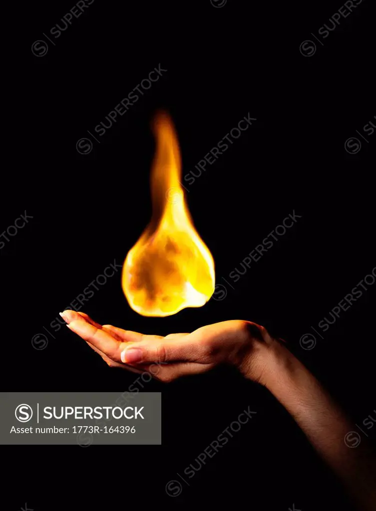 Hand holding burning flame