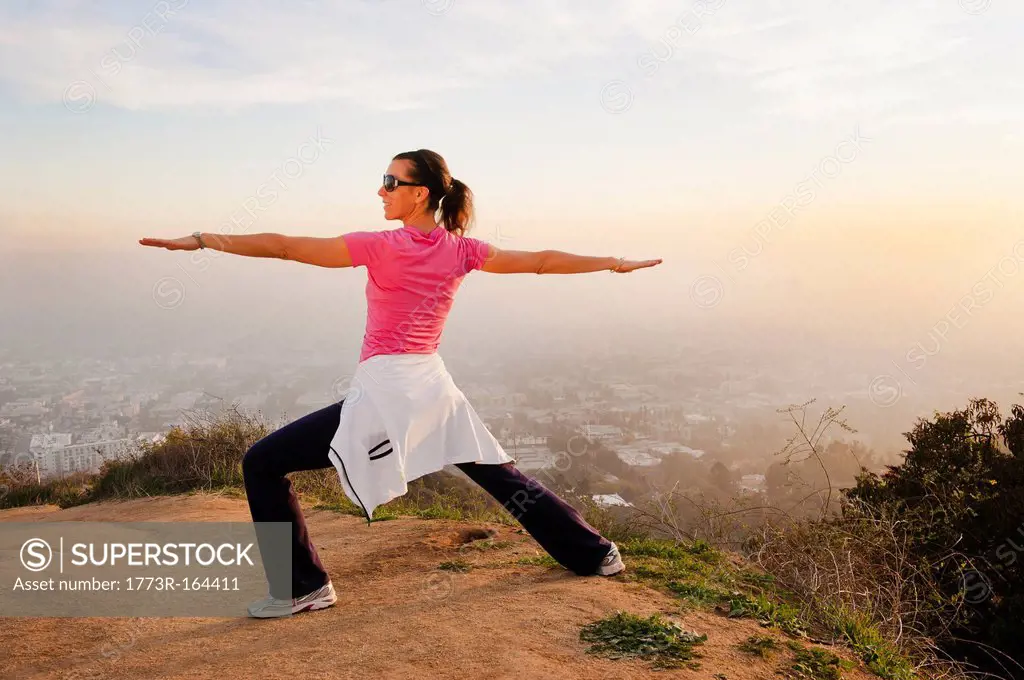 Woman stretching on hilltop