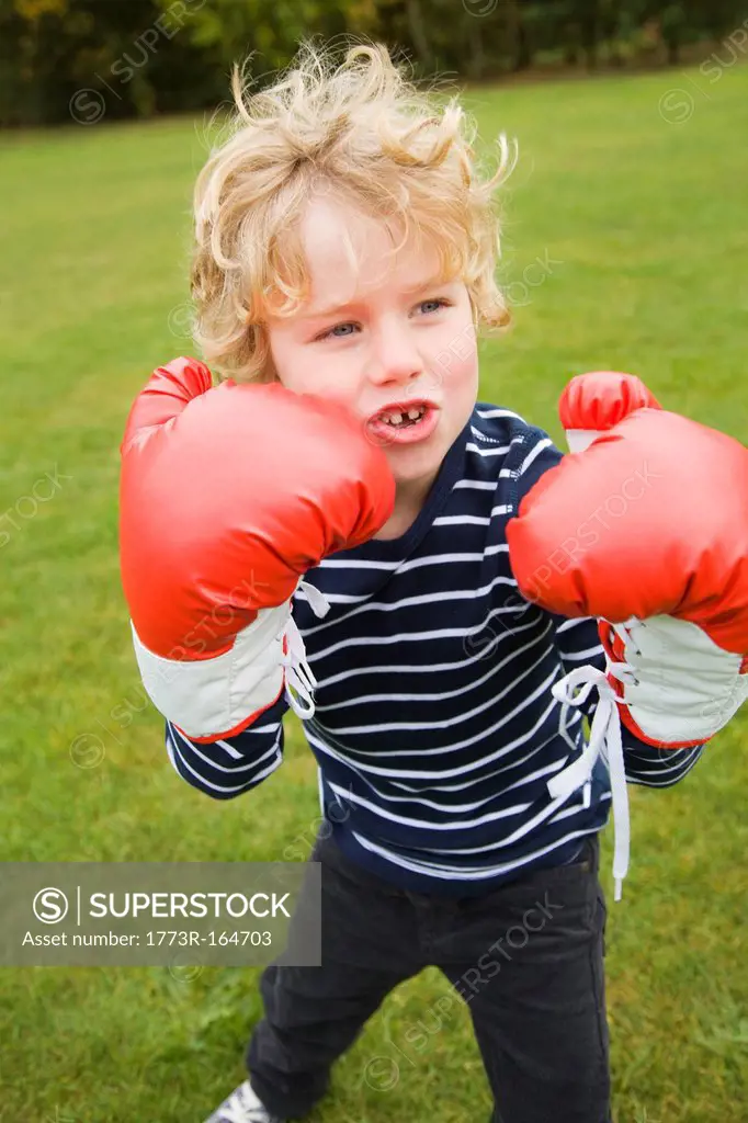 Boy playing with boxing gloves outdoors