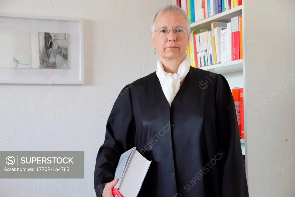 Lawyer holding text book in office