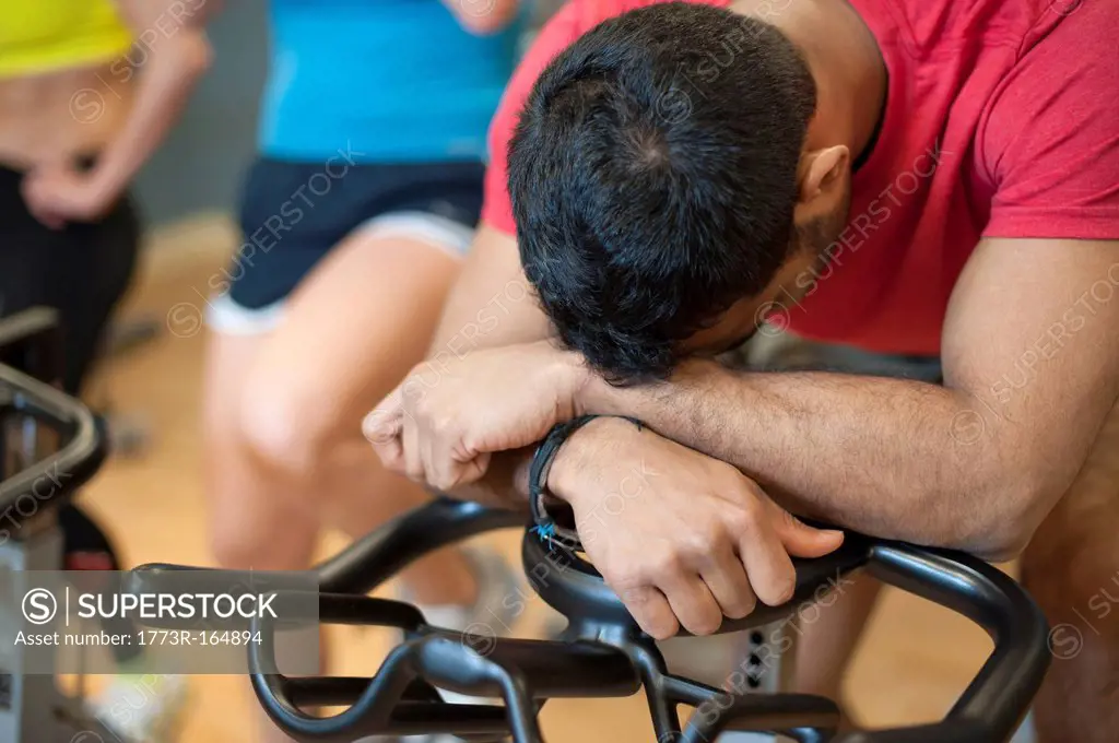 Man resting on spin machine in gym