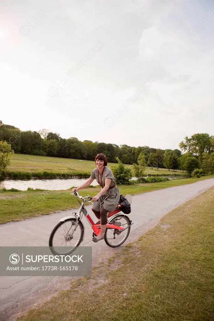 Woman riding bicycle on rural road