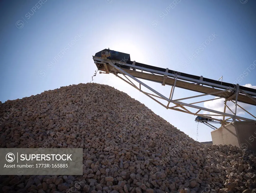 Stones pouring in pile from conveyor