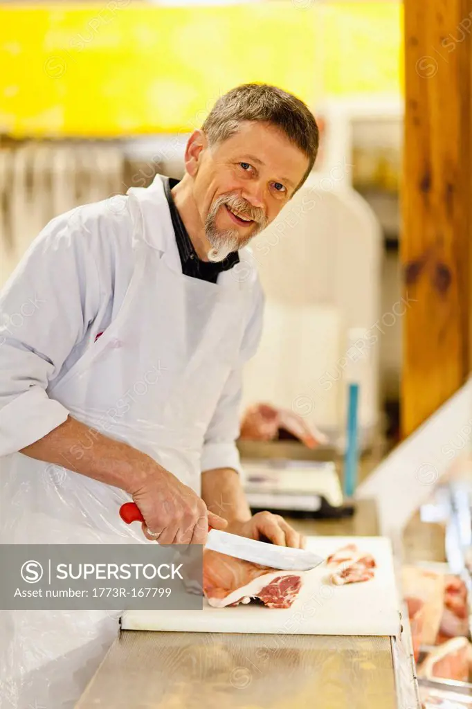 Butcher slicing meat at counter