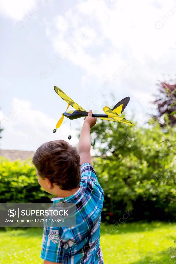 Boy playing with toy airplane outdoors